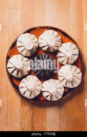 Khinkali boulettes géorgiennes noir avec de la viande sur plaque blanche. Banque D'Images