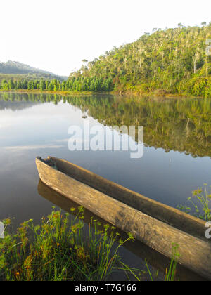 Bateau en bois reposant le long du rivage dans un lac naturel près de Parc National Parc Mantadia- Andasibe (Périnet), Madagascar, sur un beau matin serein. Banque D'Images