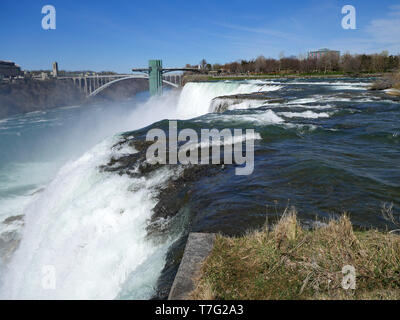 Niagara Falls, vue rapprochée de l'extrémité de la cascade avec Rainbow Bridge et Tour d'observation à l'arrière-plan Banque D'Images