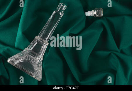 Récipient en verre vide sous la forme d'une tour eiffel sur une nappe en tissu foncé. Banque D'Images