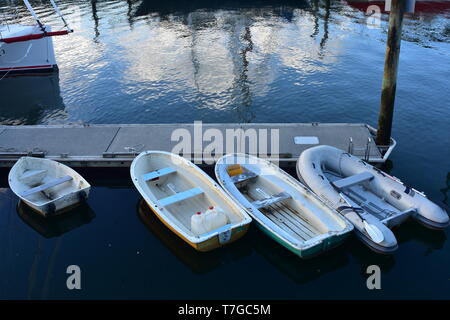 Un bateau pneumatique et en plastique liée à la jetée flottante à marina dans le centre de Whangarei en soirée. Banque D'Images