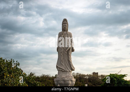 Dame contre le ciel nuageux de Bouddha dans un temple bouddhiste. MUI ne. Le Vietnam. Banque D'Images