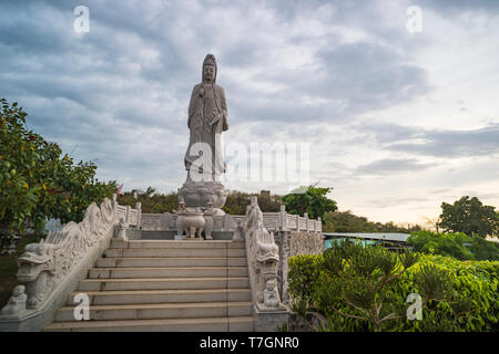 Dame contre le ciel nuageux de Bouddha dans un temple bouddhiste. MUI ne. Le Vietnam. Banque D'Images