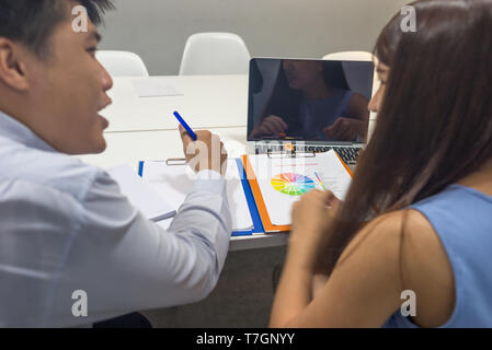 L'équipe d'affaires pour discuter les uns les autres sur les rapports de ventes Banque D'Images