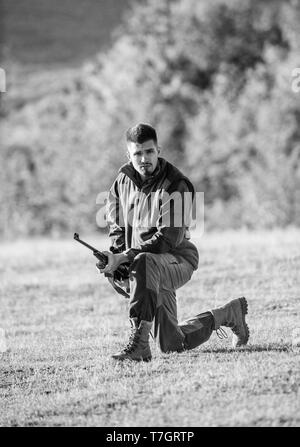 Tir de chasse trophée. Hunter au fusil à la animal. La chasse comme passe-temps masculin et les loisirs. Chargement de fusil de chasse l'homme. Vêtements kaki Hunter chasse fusil prêt à tenir l'arrière-plan des montagnes. Banque D'Images