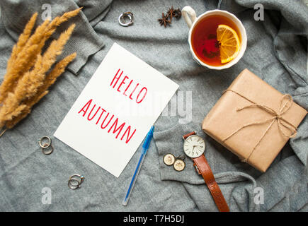 Belle tasse de thé au citron, et cértificat de différents accessoires sur fond tricoté gris . Automne-hiver confortable concept. Banque D'Images