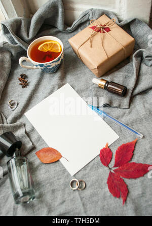 Belle tasse de thé au citron, et cértificat de différents accessoires sur fond tricoté gris . Automne-hiver confortable concept. Banque D'Images