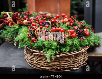 Décoration de Noël traditionnel européen, avec sapin, pommes de pin et de baies d'dogrose twiggen dans un panier. Banque D'Images