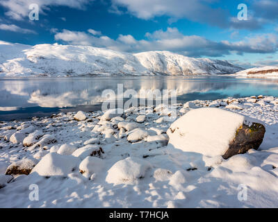 Scène idyllique avec snow voverd les rochers et les montagnes lointaines. Gamme montagne pente reflète dans eaux de fjord du nord Banque D'Images