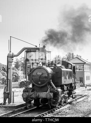 Locomotive à vapeur britannique vintage monochrome dans les sidings à la gare de Severn Valley Kidderminster prenant sur l'eau, train à vapeur équipage par grue d'arrêt d'eau Banque D'Images