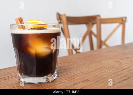 Préparer le café froid nitro avec de la glace, de la cannelle et citron sur table et chaises en bois définir comme un menu de boissons spéciales prêt à servir pour le client sur le café Banque D'Images