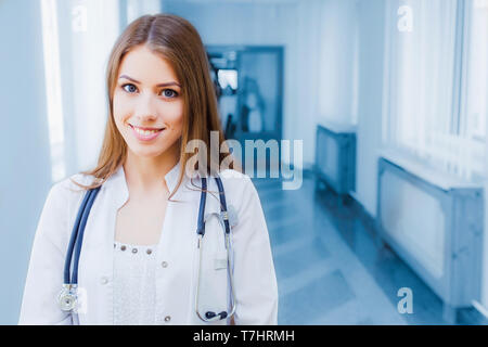 Confident female doctor sitting at office desk and smiling at camera, soins de santé et de prévention concept Banque D'Images
