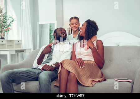 Happy smiling libre de trois assis sur le canapé Banque D'Images