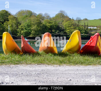 Rangées de kayaks de couleur vive sur le côté d'une piste par la mer Banque D'Images