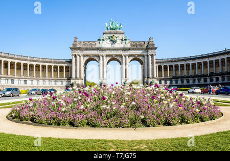 L'arcade du Cinquantenaire, l'Arc de triomphe dans le parc du Cinquantenaire à Bruxelles, Belgique, sur une journée ensoleillée avec un parterre de fleurs au premier plan. Banque D'Images