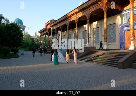 Les habitants participant à une séance de photographie pré mariage passent devant le Musée des victimes de la répression politique qui raconte l'histoire de l'Ouzbékistan à l'époque de l'Union soviétique situé dans la capitale de l'Ouzbékistan Tachkent Banque D'Images