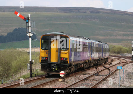 Train du Nord laissant à Garsdale station sur la ligne de chemin de fer s'installer à Carlisle signal sémaphore de passage le 30 avril 2019. Banque D'Images