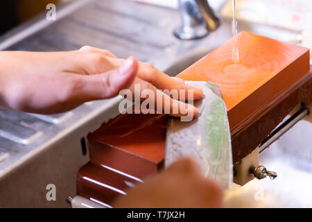 Femme chef professionnel mains le couteau pour aiguiser aiguiser sur.premium professional stone du Japon.l'affûtage avec sha traditionnels Banque D'Images