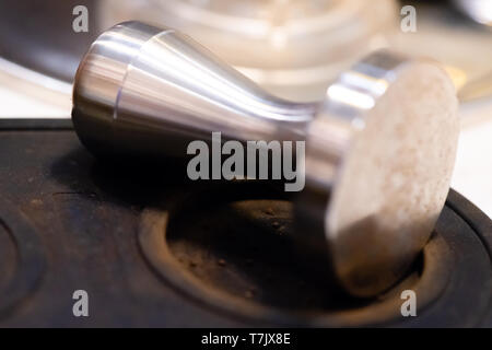 Tamper barista en acier inoxydable.équipement lourd.intégrité pour barista professionnel brew café expresso.close up modifier dans un café avec l'espace. Banque D'Images