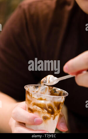 Close up aller manger une glace à la vanille avec fondant au chocolat en tasse.mains man eating ice cream avec vanille Fondant au chocolat sur le dessus.délicieux bonbons glace vanille Banque D'Images