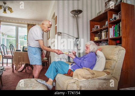 93 ans, homme, et avec l'état de coeur prend soin de ses gravement déficients visuels 90 ans femme prepaeres,cuisiniers et les repas et ne ménage pour elle. Banque D'Images