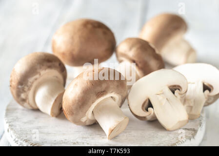 Champignon champignons - ensemble et ceux de moitié- sur la planche de bois blanc Banque D'Images