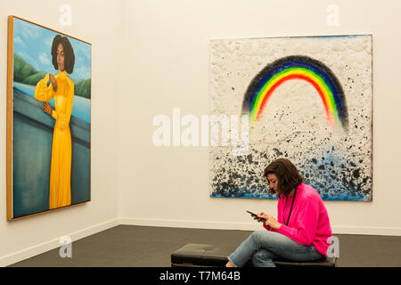 New York, NY - 3 mai 2019. Une femme sur son téléphone correspond à une couleur arc-en-ciel dans une peinture illustré par la moitié de New York à la galerie Frieze Art Fair à New York City's Island Randalls. Banque D'Images