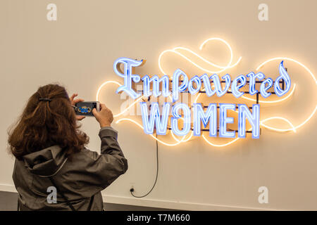 New York, NY - 3 mai 2019. Une femme prend une photo d'une sculpture néon qui lit 'donné aux femmes' à la Frieze Art Fair de New York City's Island Randalls. Banque D'Images