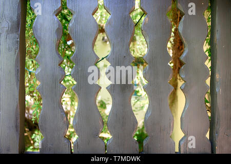 Découpes en bois dans une porte menant à un jardin clos. Banque D'Images