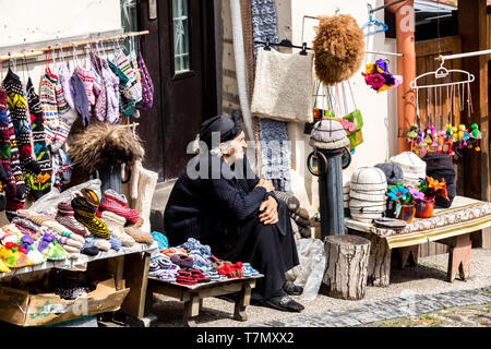 Sighnaghi, Géorgie - 10 juin 2016 : vente du vendeur chaussettes, chaussons en laine et des souvenirs dans la rue de Kakheti, ville Sighnaghi . Banque D'Images