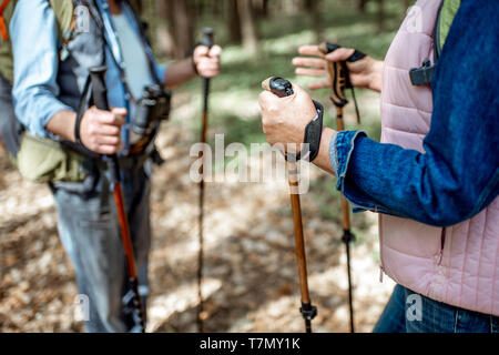 Man and Woman randonnées avec des bâtons de trekking dans la forêt, vue rapprochée avec la face coupée Banque D'Images