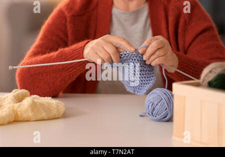 Senior woman knitting chaussette chaude à table Banque D'Images