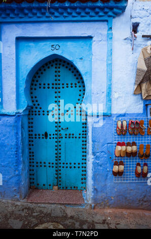 Chefchaouen, Maroc : porte en bois traditionnel dans le bleu à la chaux medina vieille ville. Banque D'Images