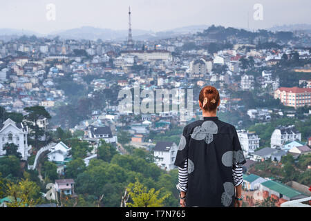 Belle femme donnant sur la vue sur la ville, Dalat, Vietnam Banque D'Images