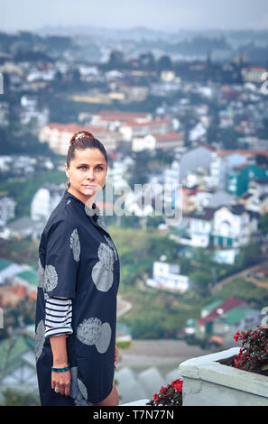 Belle femme donnant sur la vue sur la ville, Dalat, Vietnam Banque D'Images