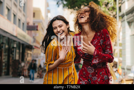 Femme amis ensemble à marcher le long de la rue de la ville. Heureux les jeunes femmes s'amuser en plein air. Banque D'Images