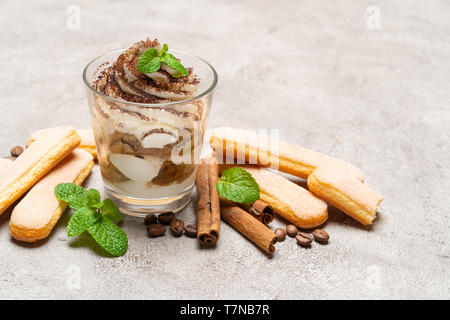 Dessert tiramisu classique dans un verre et les cookies sur fond de béton savoiardi Banque D'Images