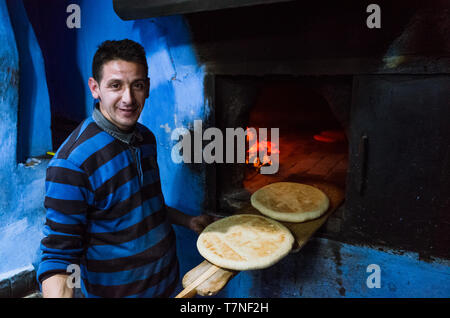 Chefchaouen, Maroc : Portrait de l'homme au pain plat au four un four traditionnel dans le bleu à la chaux medina vieille ville. Banque D'Images