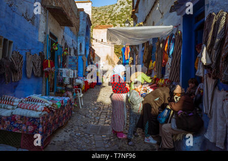 Chefchaouen, Maroc : scène de rue avec des gens dans le bleu à la chaux ruelles de la médina, vieille ville. Banque D'Images