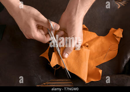 L'homme en cuir de coupe dans l'atelier Banque D'Images