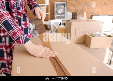 Woman packing carton à l'intérieur. Déménagement house concept Banque D'Images