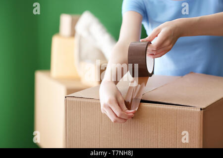 Woman packing carton à l'intérieur. Déménagement house concept Banque D'Images