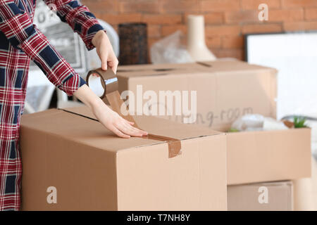 Woman packing carton à l'intérieur. Déménagement house concept Banque D'Images