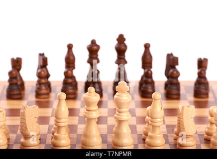 Jeu d'échecs en bois noir et blanc pieces standing in a row sur un échiquier, isolé sur fond blanc Banque D'Images