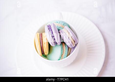 Macarons français colorés doux ou macaron sur fond de marbre blanc. Vue de dessus, copy space Banque D'Images