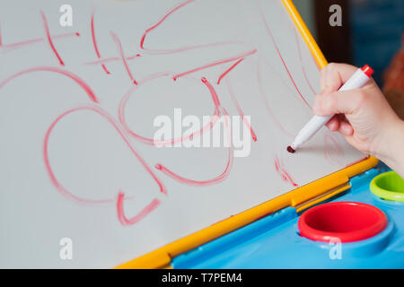 Une fillette de quatre ans son écriture pratiques sur un tableau. Banque D'Images