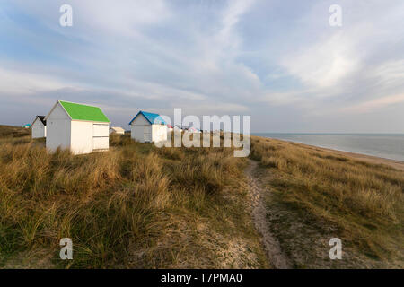 Voie à une rangée de cabanes de plage avec des toits colorés sur une dune couverte d'herbe et belle vue sur l'océan atlantique, Gouville-sur-Mer, Normandie, France Banque D'Images