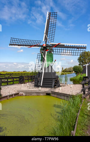 Petit Moulin Vert personnel néerlandais au milieu d'un petit canal de la vidange de l'eau sur le terrain Banque D'Images