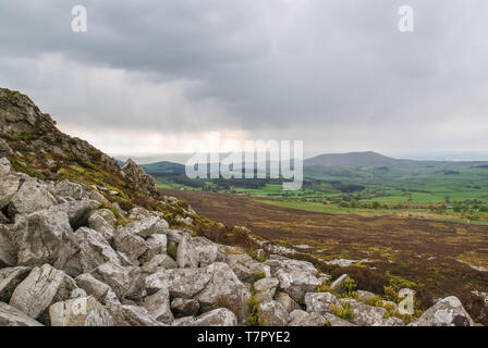 Une vue de rochers effondrés et orageux ciel au-dessus de paysage lointain à Stiperstones Nature Reserve, Shropshire, Angleterre Banque D'Images