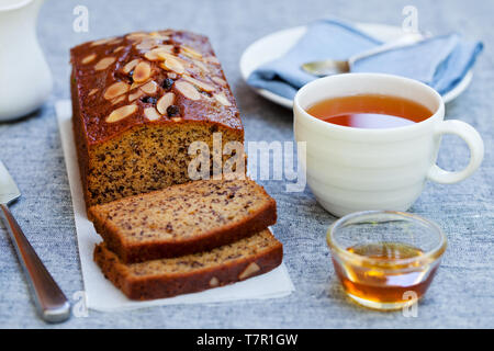 La banane, carotte, pomme de pain, gâteau au chocolat et une tasse de thé sur fond gris. Banque D'Images